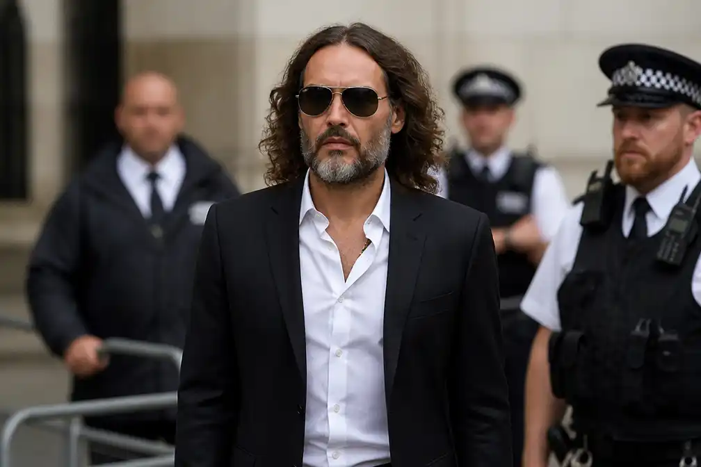 Russell Brand bij rechtbank aan start van proces om verkrachting en aanranding