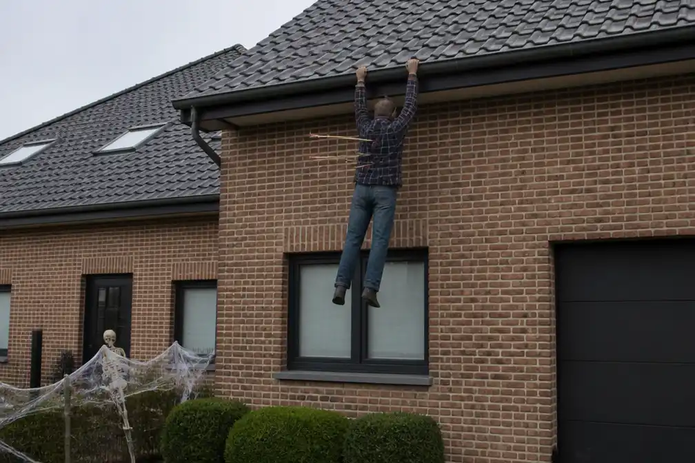 Man met drie pijlen in de rug hangt aan dak als halloweenversiering in Erps-Kwerps